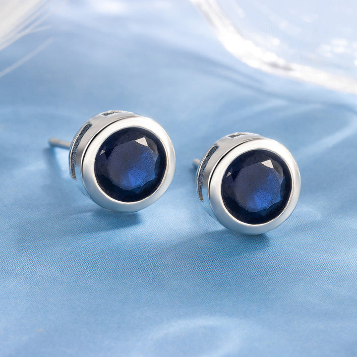 Boucles d'oreilles à clou avec lunette en saphir | Or blanc