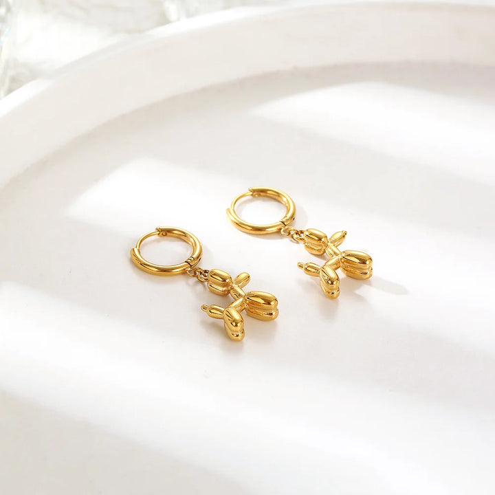 Boucles d'oreilles Huggie en or avec charme de mini chien en ballon